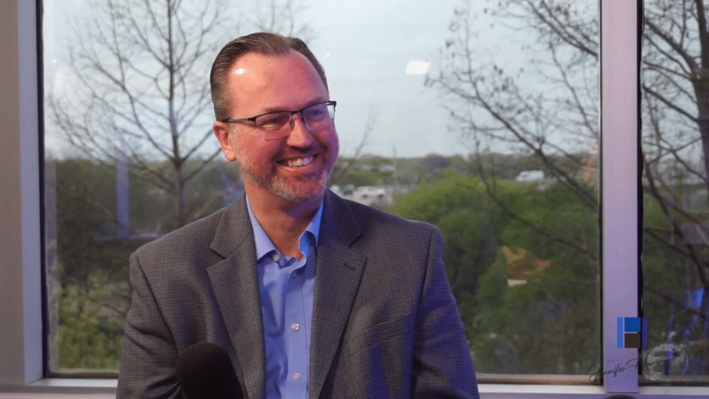 Smiling man in glasses during interview indoors
