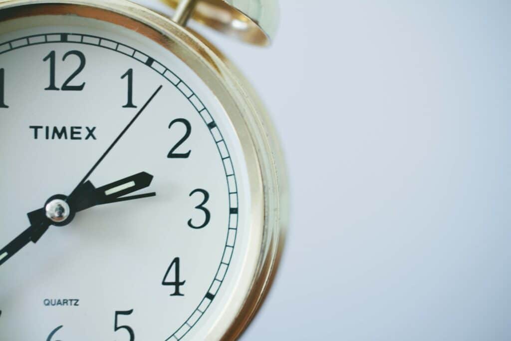 Close-up of analog Timex clock showing 2:05