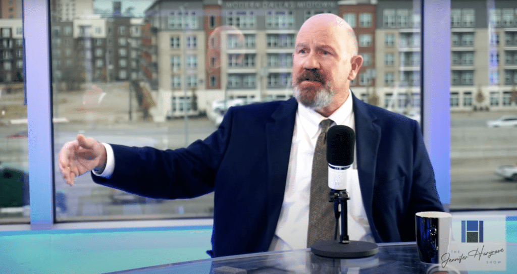 Man in suit speaking into studio microphone