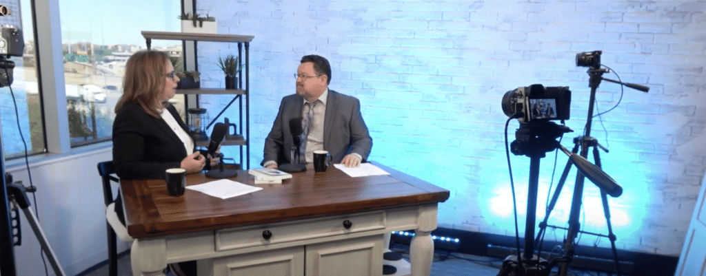 Two people recording interview in studio with cameras