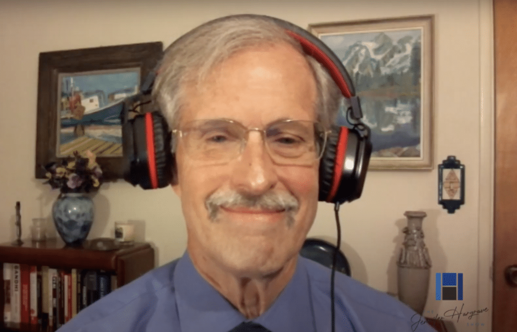 Smiling older man wearing headphones in home office