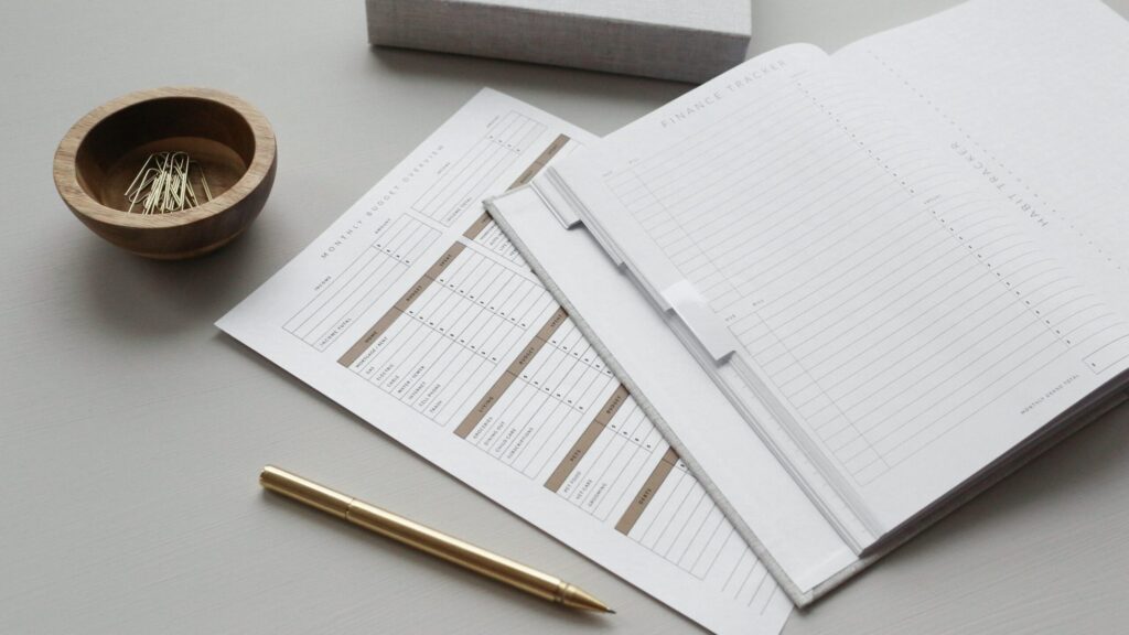 Finance planner with budget sheets and gold pen