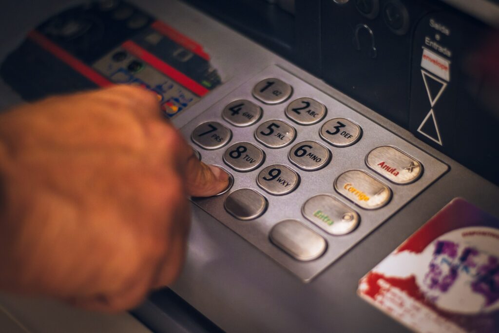 Hand entering PIN on ATM keypad