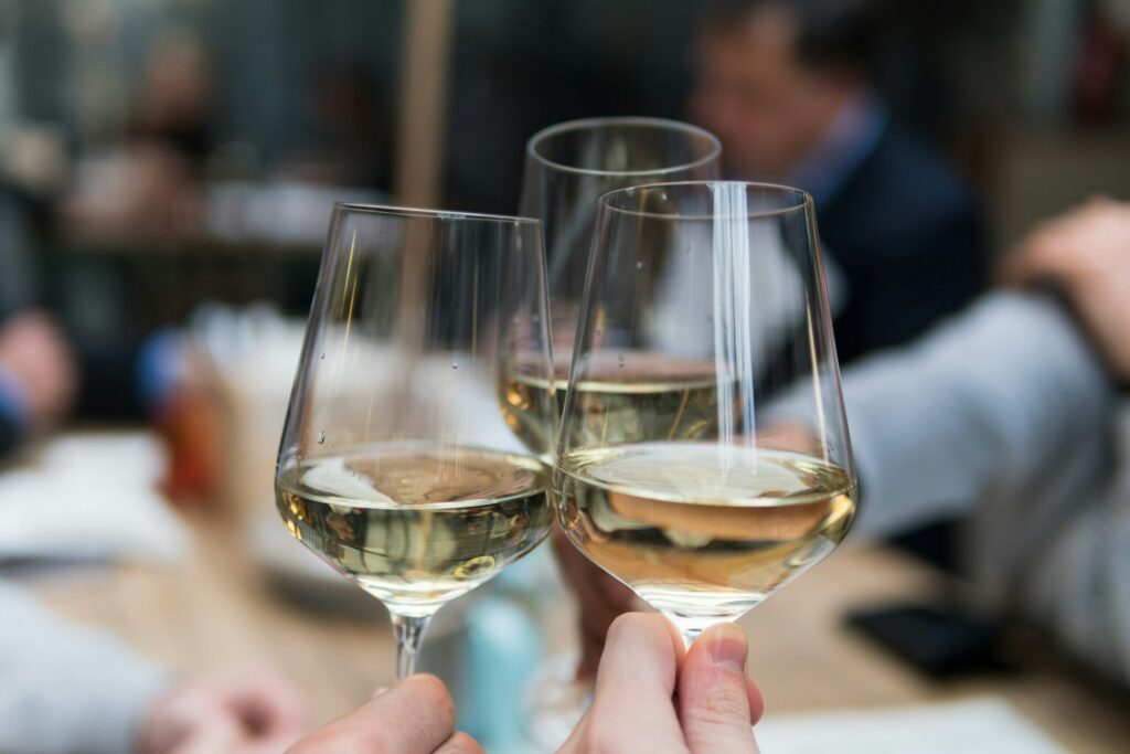 Three glasses of white wine toasting