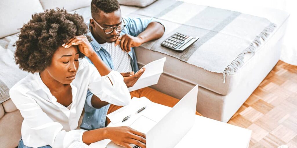 Couple reviewing bills looking stressed at home