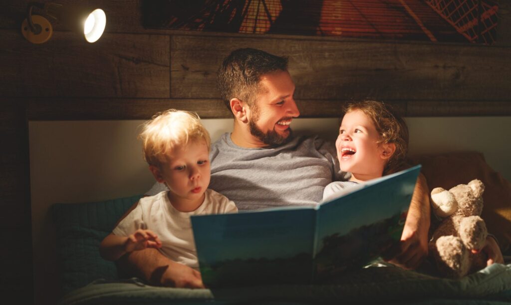 Father reading bedtime story to two children
