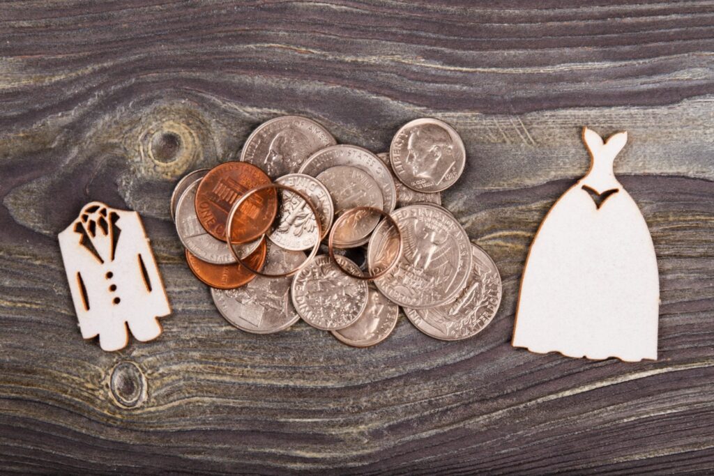 Wedding rings on coins between bride and groom cutouts
