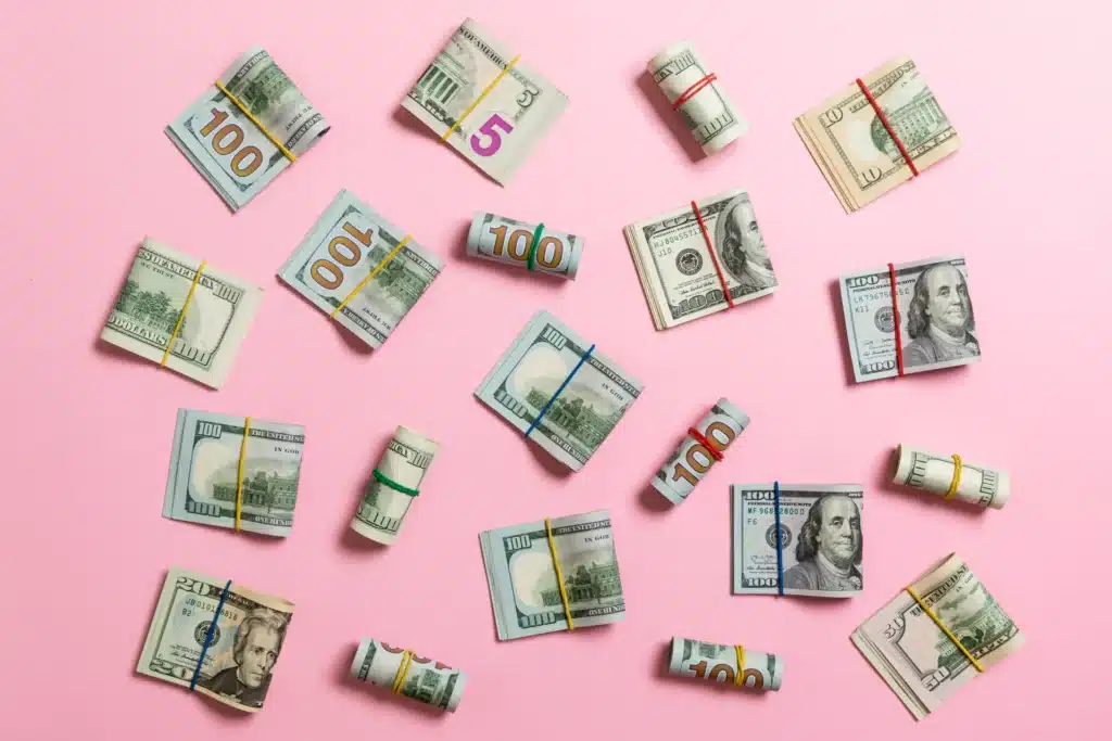 Bundles of U.S. dollar bills on pink background