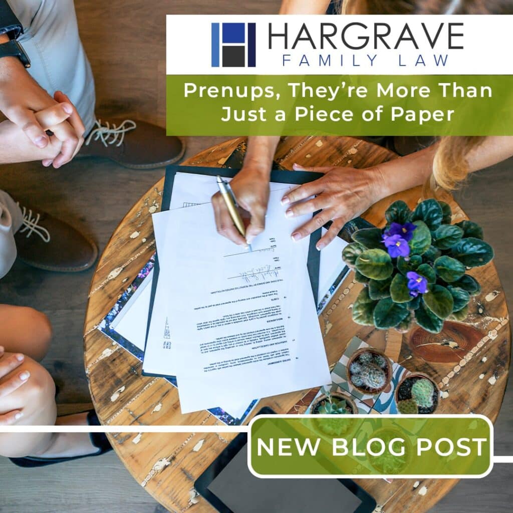 Couple signing prenuptial agreement at wooden table