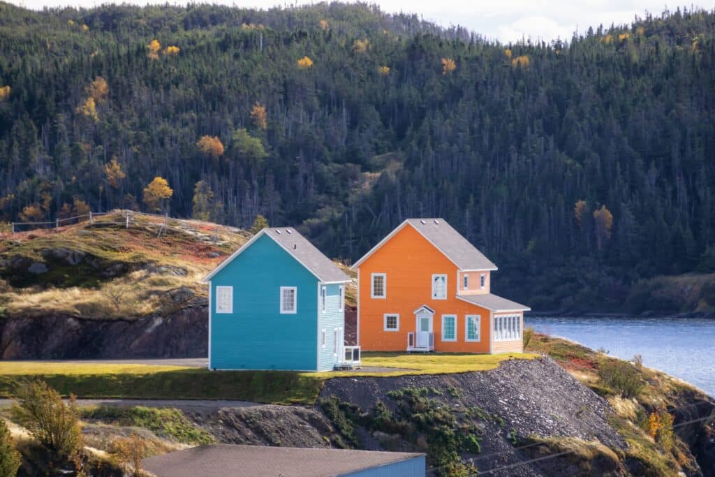 Colorful houses on cliff overlooking forest and water