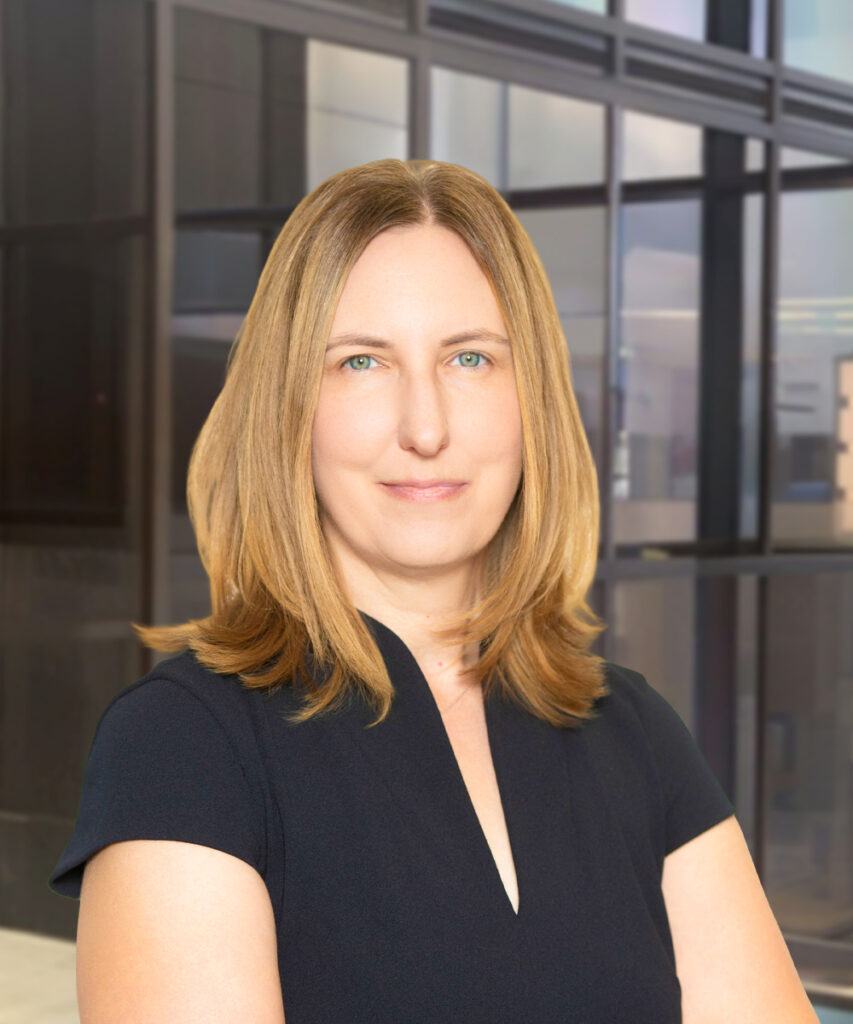 Professional woman in dark dress posing in modern office