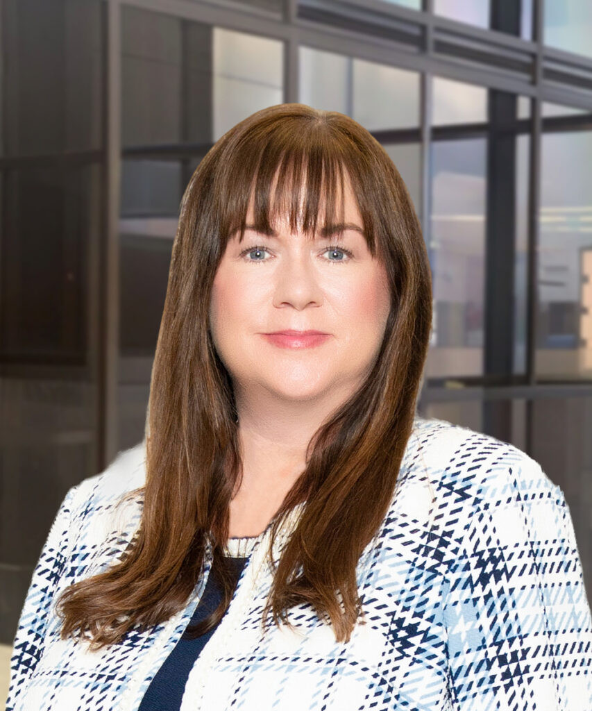 Professional woman in patterned blazer posing in modern office