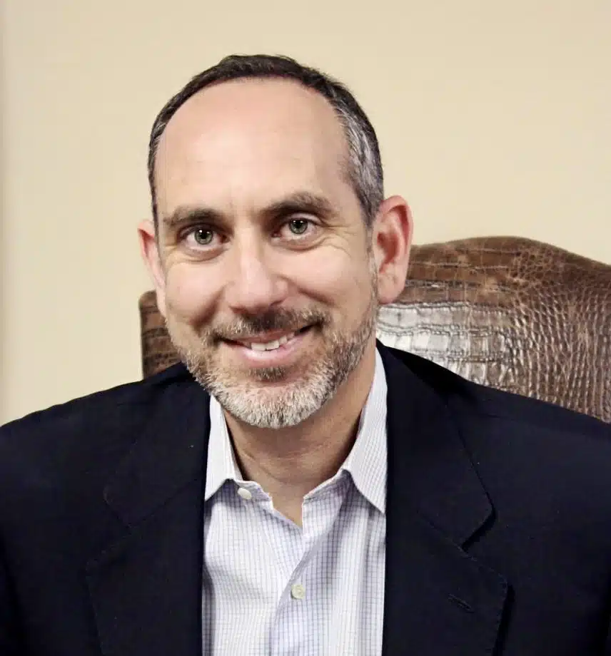 Smiling man in blazer seated in leather chair