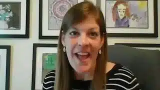 Woman speaking in front of framed artwork