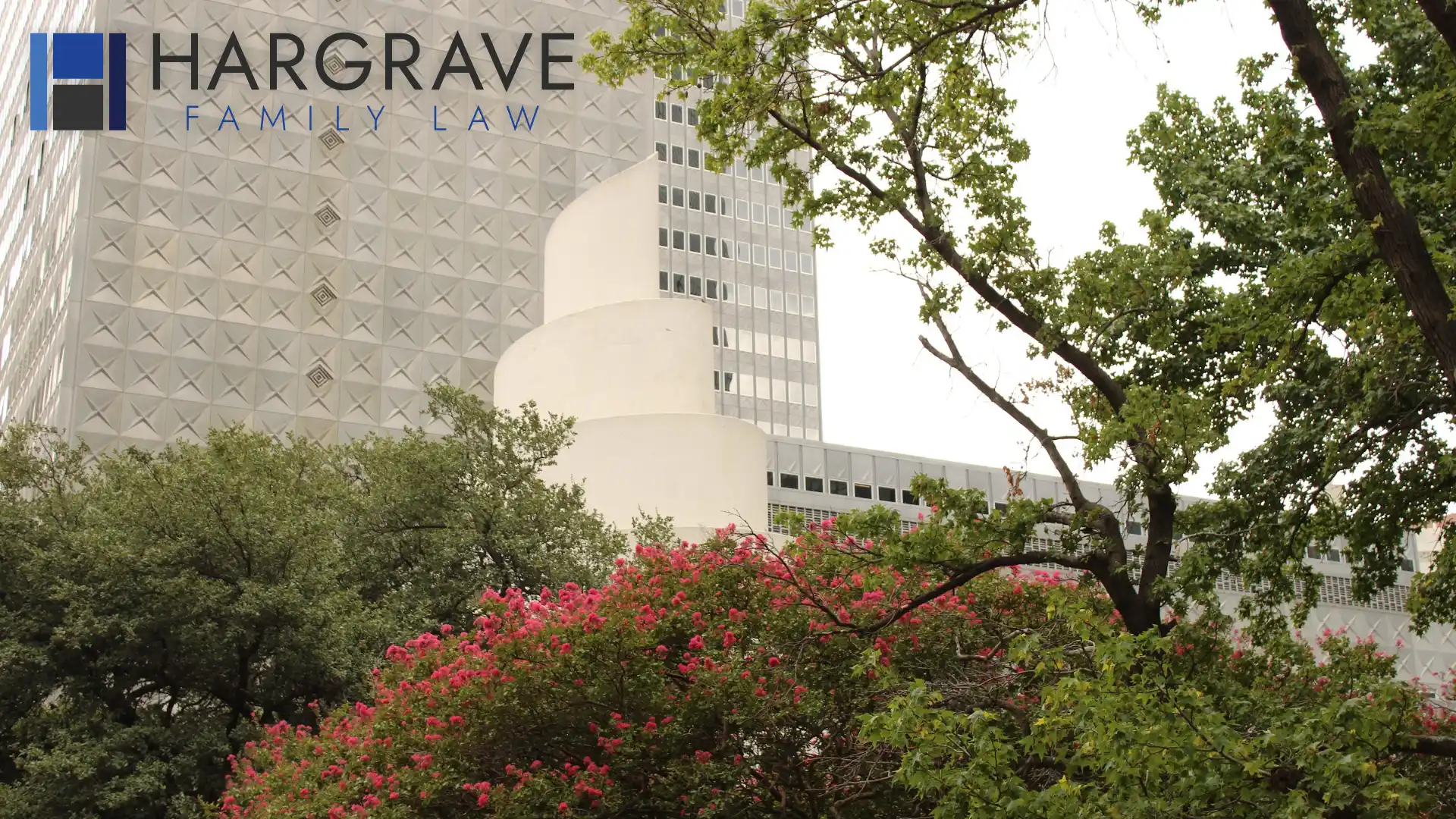 A tree-lined downtown Dallas street in summer bloom, where parents work through child custody and visitation schedules.