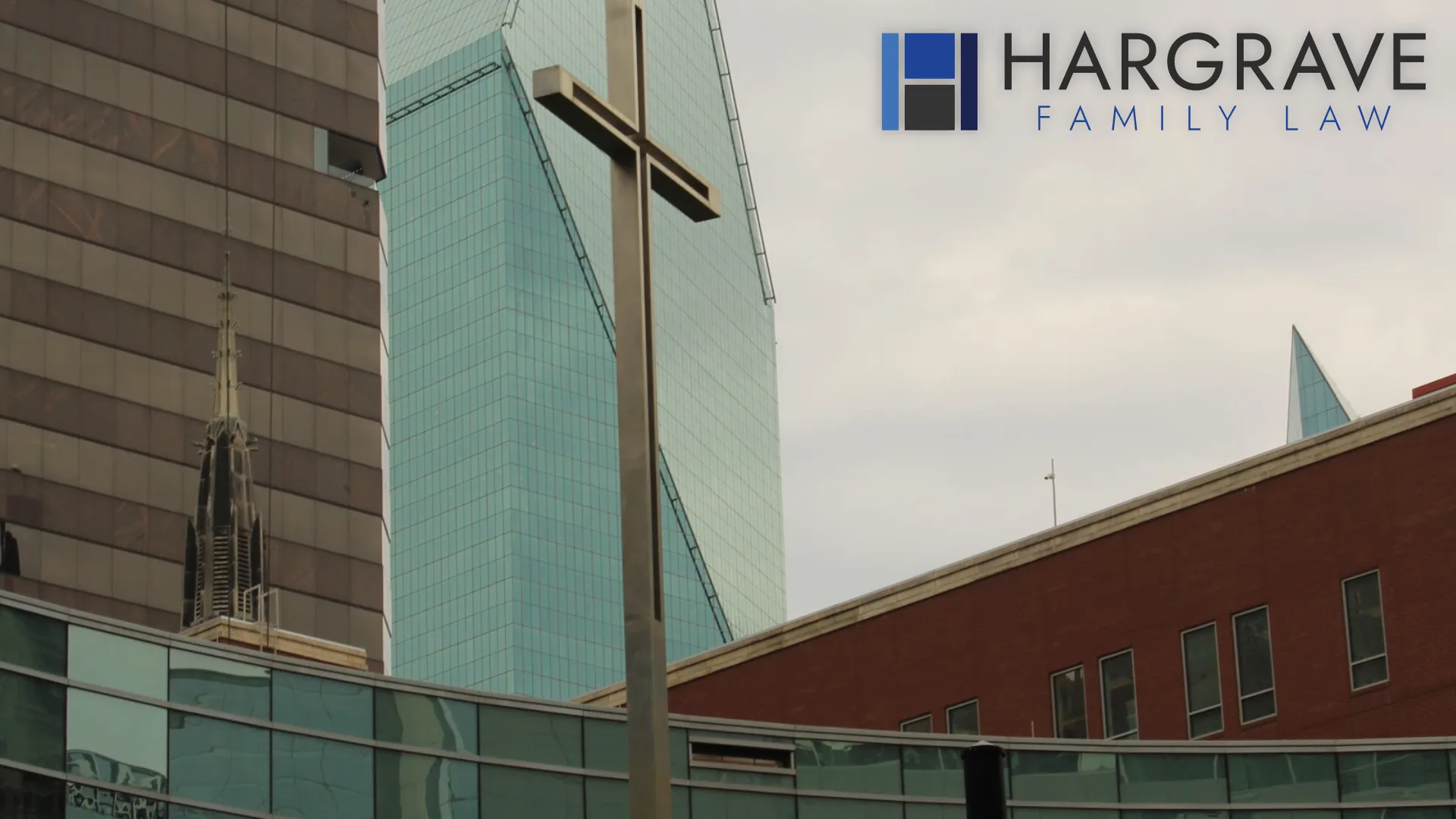 A church cross rising beside a glass tower in downtown Dallas, near the support resources spouses use when addiction affects a divorce.